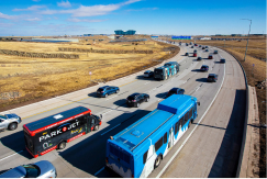 A photo of vehicles, including a DEN shuttle, traveling on Peña Boulevard heading towards the airport.